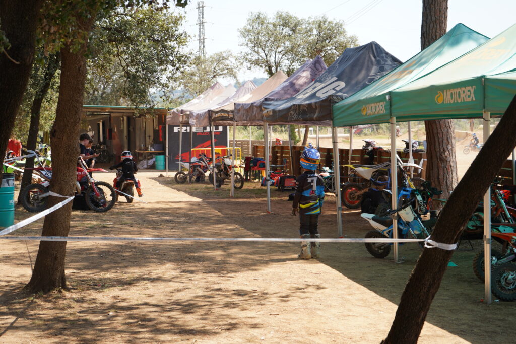 Zona de convivencia con mesas y carpas junto al circuito de motocross